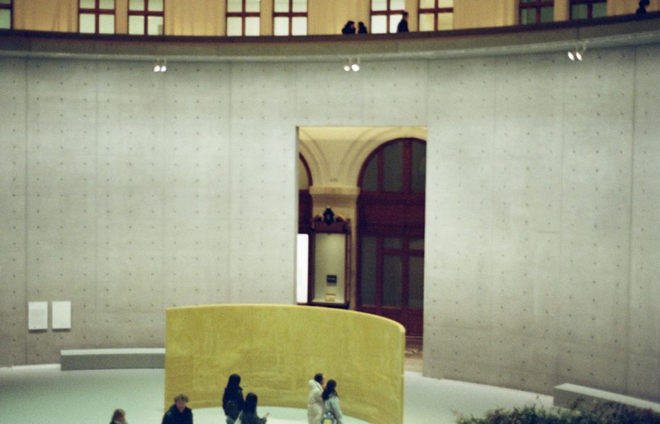 Zwiedzający w nowoczesnym muzeum z betonowymi ścianami