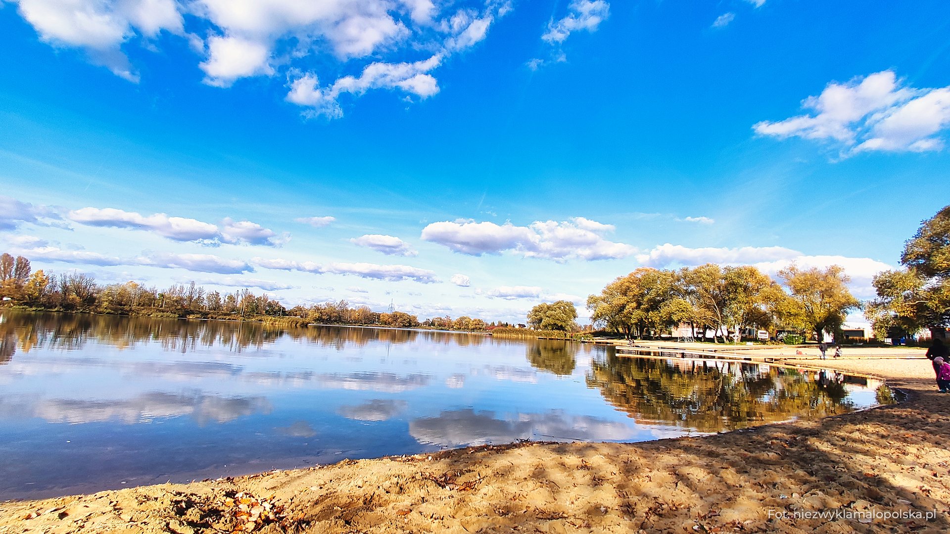 Calm lake at Przylasek Rusiecki with clouds reflected in the water