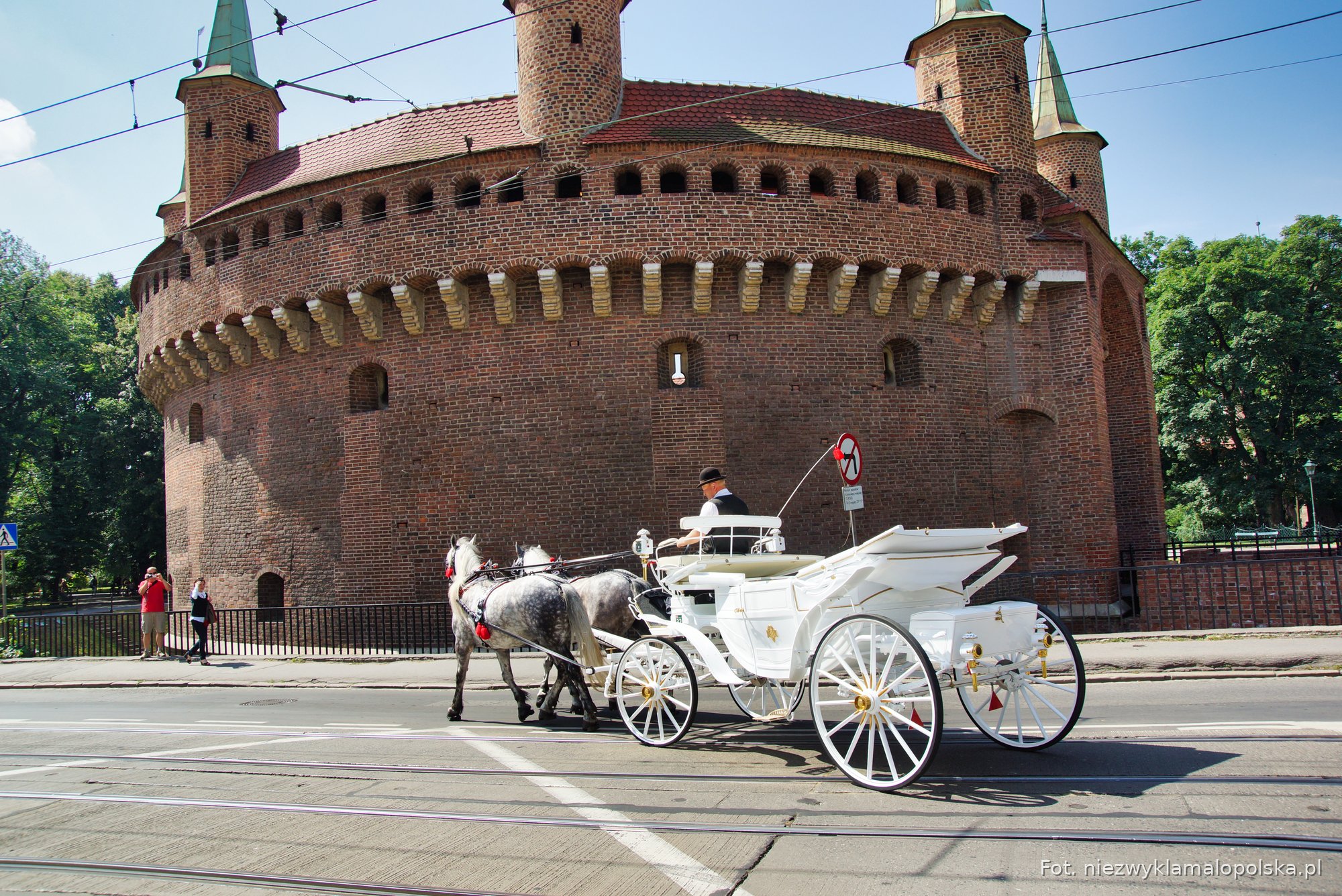 The round brick Barbican in Kraków with a horse carriage in front